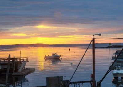 A serene sunset photograph of lobster fishing, capturing the tranquil waters and silhouettes of fishermen by Jimmy Kirk.